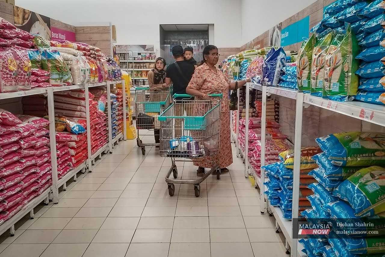 Customers compare rice prices at a supermarket in Ampang, Selangor.