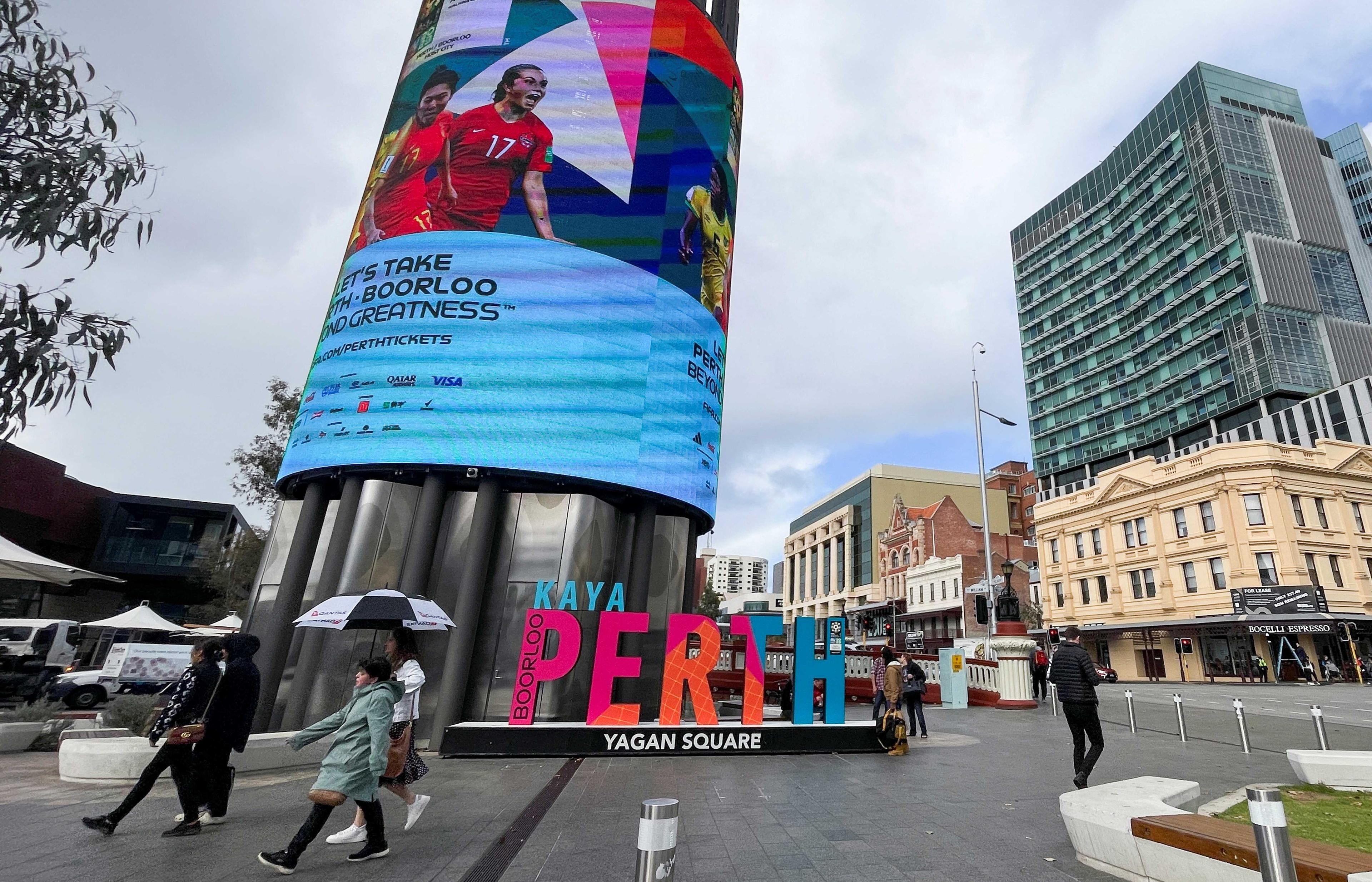 People walk in front of a billboard, July 19, Perth, Australia. Photo: Reuters