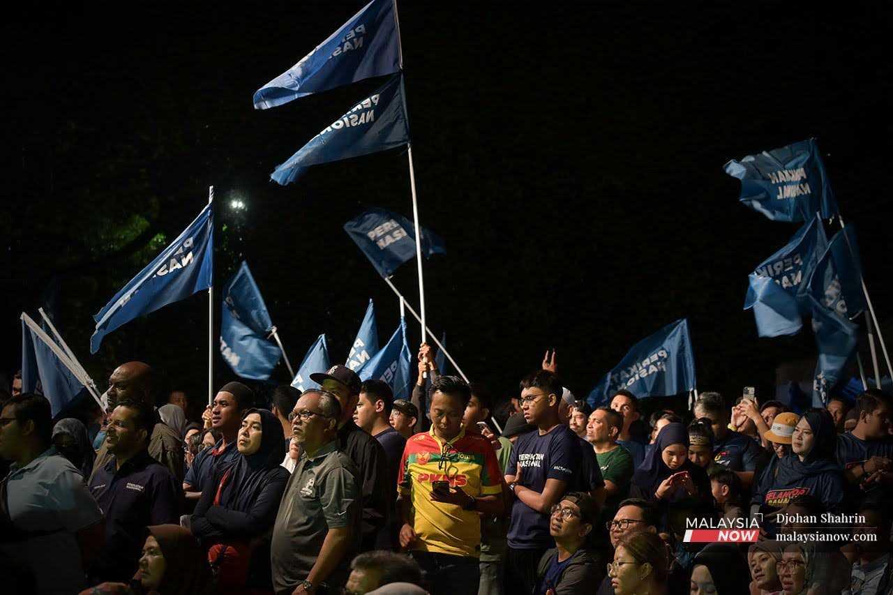 People hold Perikatan Nasional flags at a ceramah event ahead of the Selangor election in Taman Melawati, Hulu Kelang, Aug 11.