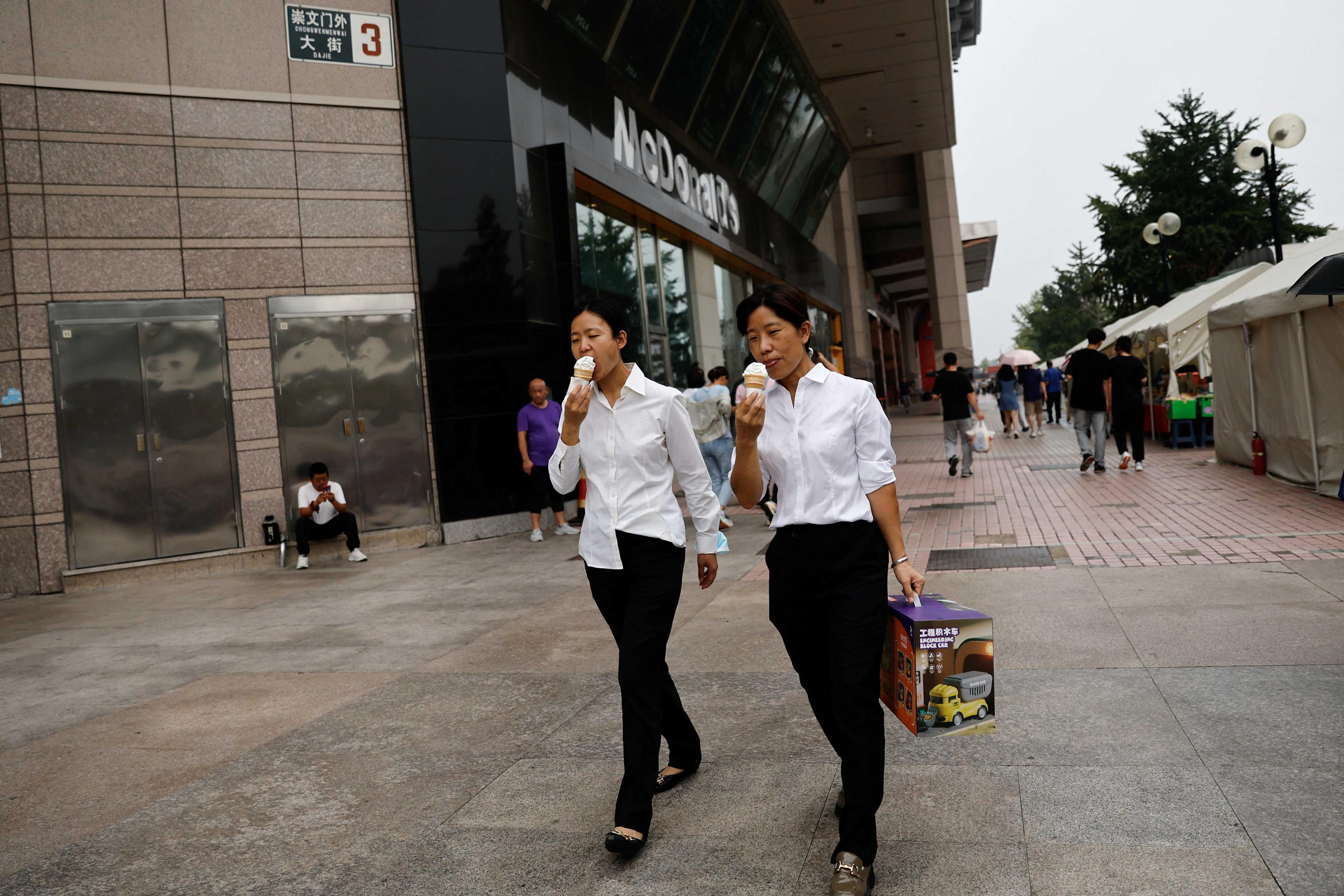 Orang ramai makan aiskrim semasa berjalan di jalan di Beijing, China 5 September. Gambar: Reuters