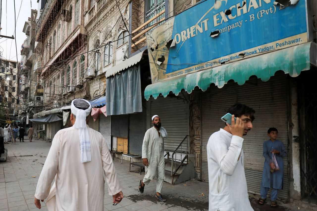 People walk along closed foreign exchange shops, in Peshawar, Pakistan Sept 7. Photo: Reuters