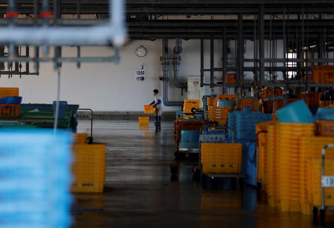 A woman works at a fishing port in Soma, about 45km away from the tsunami-crippled Fukushima Daiichi nuclear plant discharging treated radioactive water into the ocean, Japan, Aug 31. Photo: Reuters