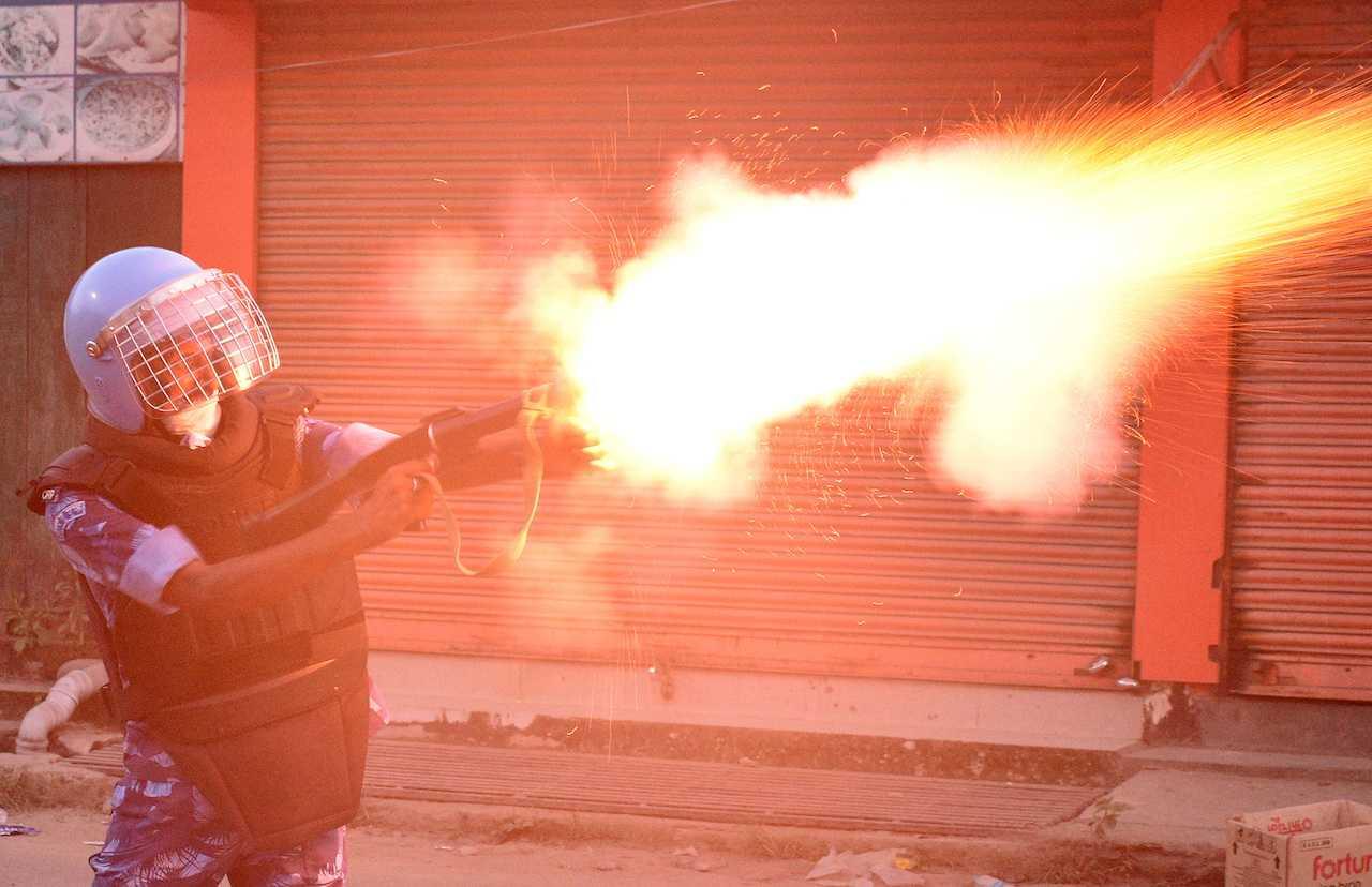 A riot police officer fires a tear smoke shell to disperse demonstrators protesting against the killing of two Meitei students in Imphal, Manipur, India, Sept 27. Photo: Reuters