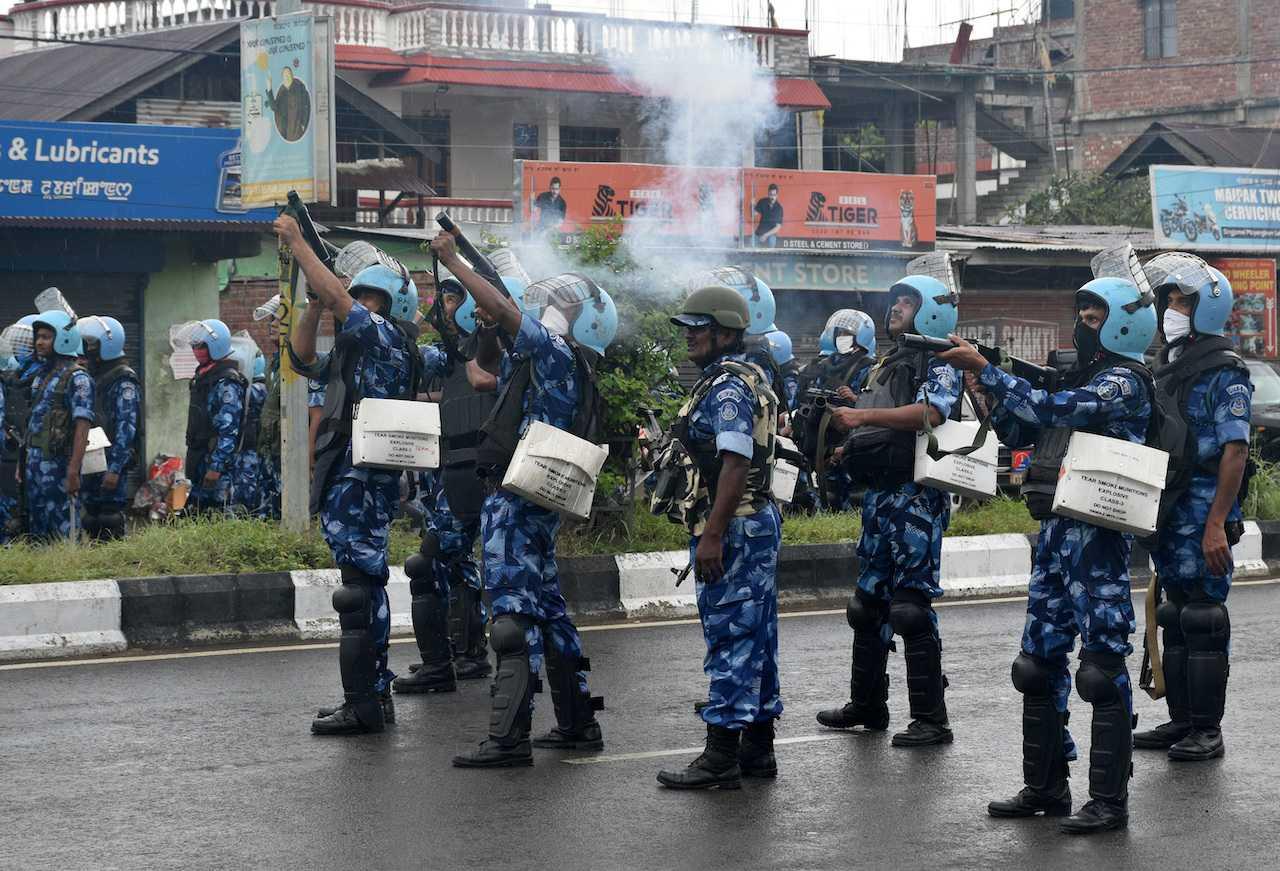 Riot police officers fire tear smoke shells to disperse demonstrators protesting against the arrest of five people, whom police said were carrying weapons while wearing camouflage uniform, in Imphal, Manipur, India, Sept 18. Photo: Reuters