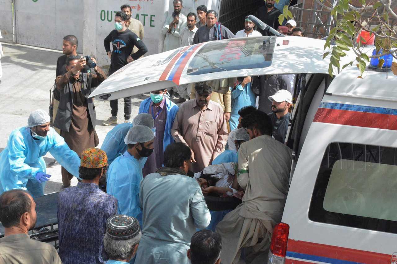 Men and paramedic staff transfer a man who was injured in a blast in Mastung from an ambulance outside hospital in Quetta, Pakistan, Sept 29. Photo: Reuters