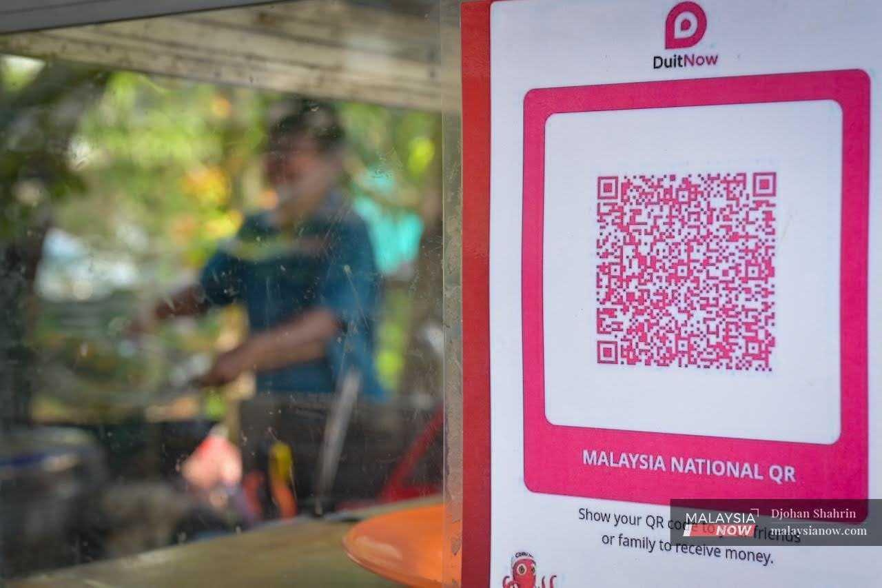 A QR code for DuitNow payments is displayed at a roadside stall in Selangor, amid concerns over charges for the use of the facility. 
