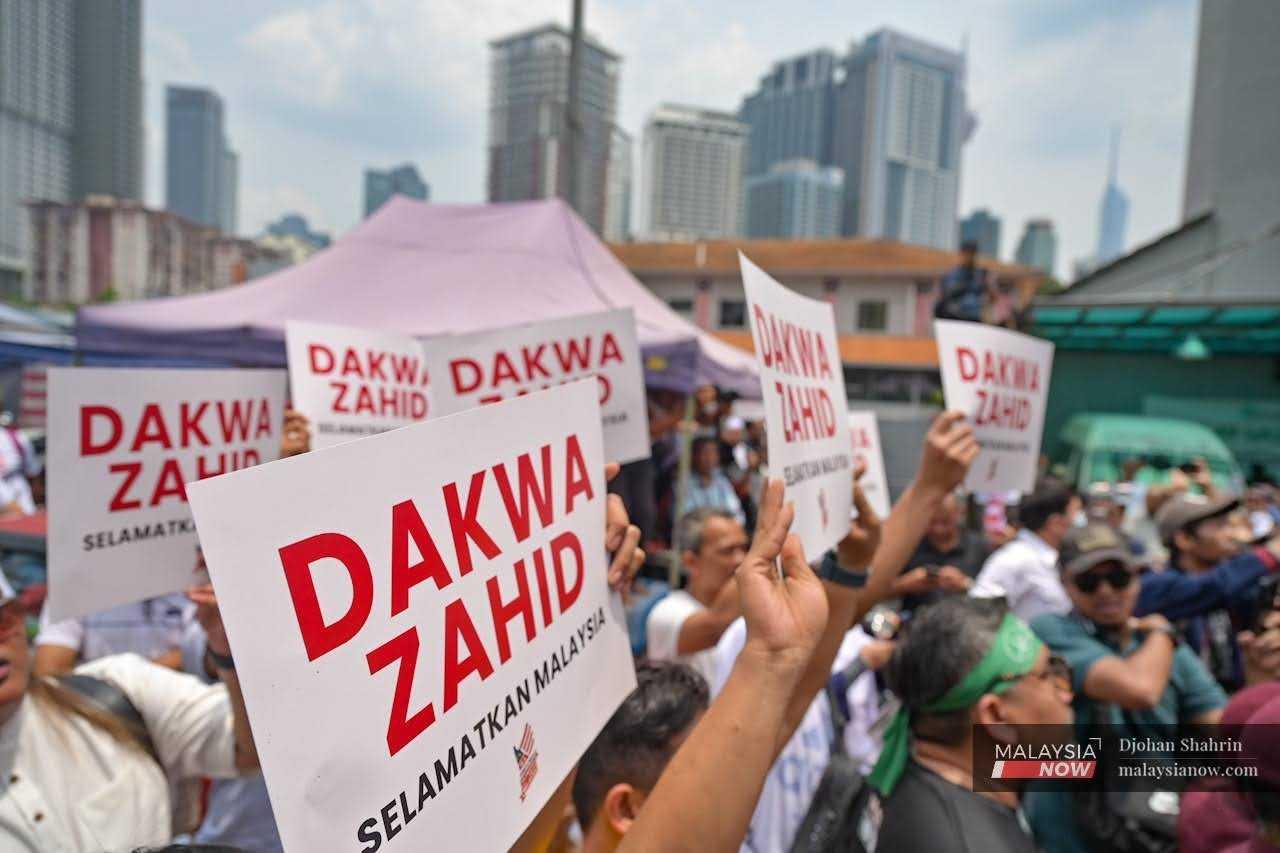 Penunjuk perasan memegang plakad ‘Dakwa Zahid’ semasa perhimpunan Selamatkan Malaysia di Kampung Baru, 16 September.
