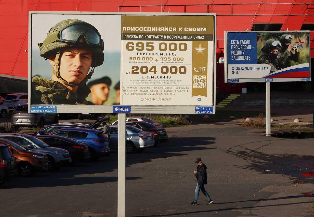A man walks past advertising boards promoting military service under the contract in Russian Armed Forces, in Saint Petersburg, Russia, Sept 21. Photo: Reuters
