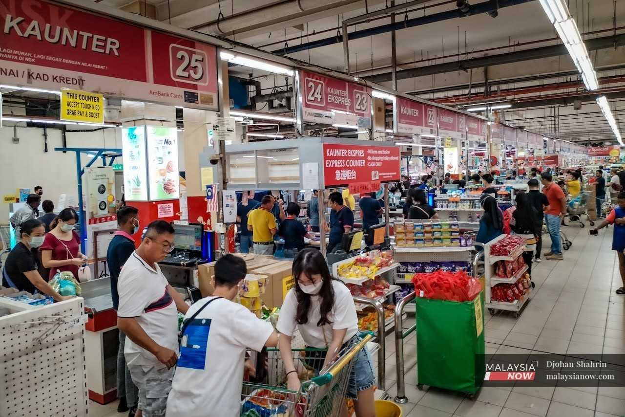 Customers queue at the checkout point of a supermarket in Taman Kuchai, Kuala Lumpur.