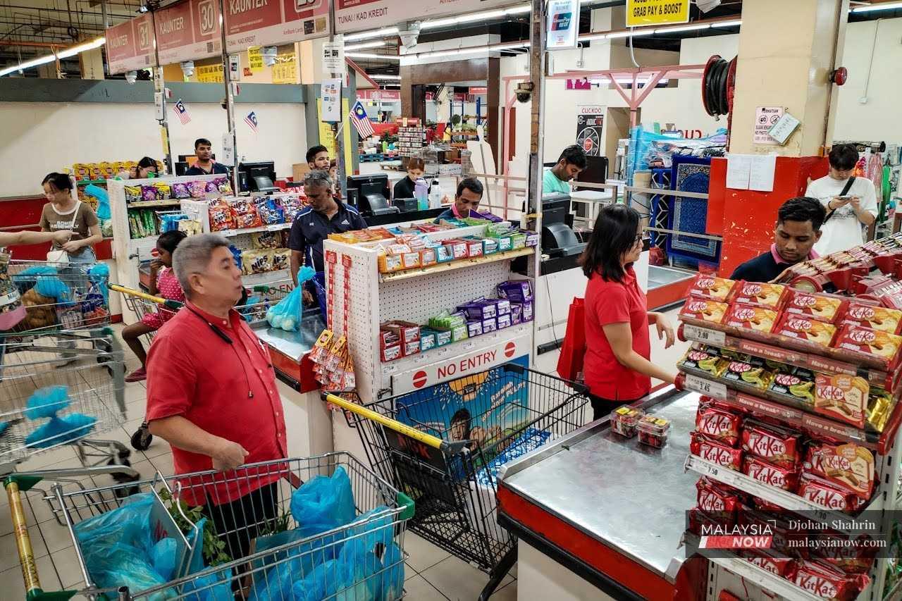 Pelanggan membuat pembayaran di kaunter di sebuah pasar raya di Taman Kuchai.