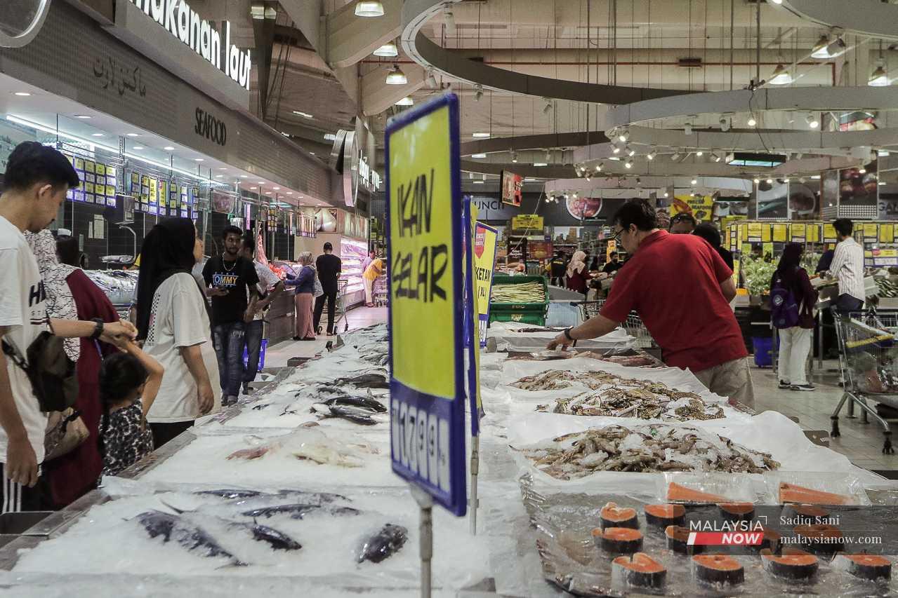 Pembeli membuat pilihan makanan laut segar di sebuah pasar raya. 