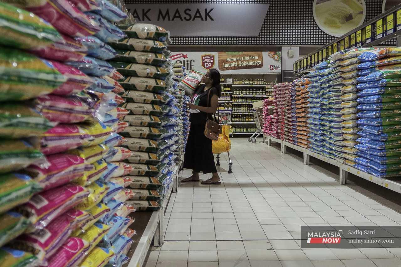 Seorang wanita mengangkat sekampit beras import di sebuah pasar raya di Subang, Selangor, ketika kebanyakan beras tempatan habis dijual. 