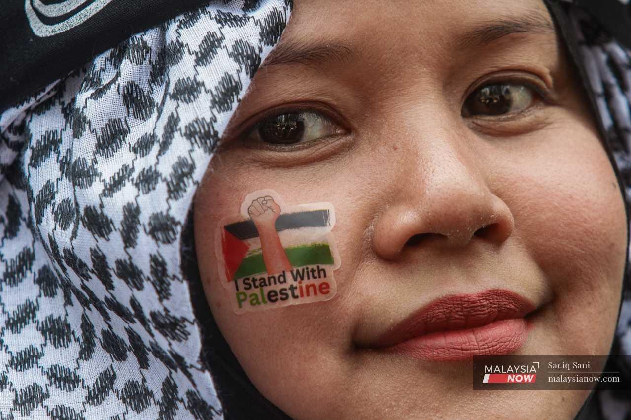 A protester with a pro-Palestine face sticker.