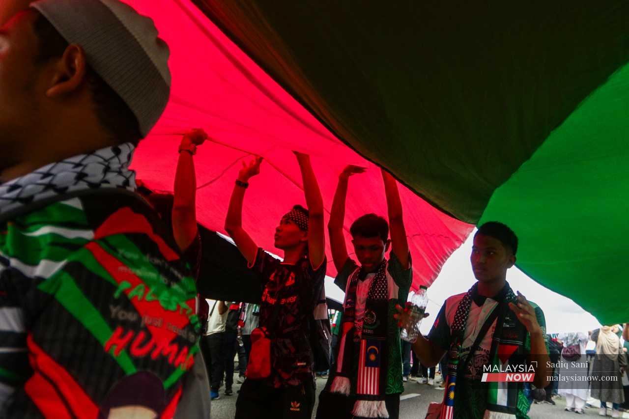 Protesters carry a giant Palestinian flag near the US embassy.