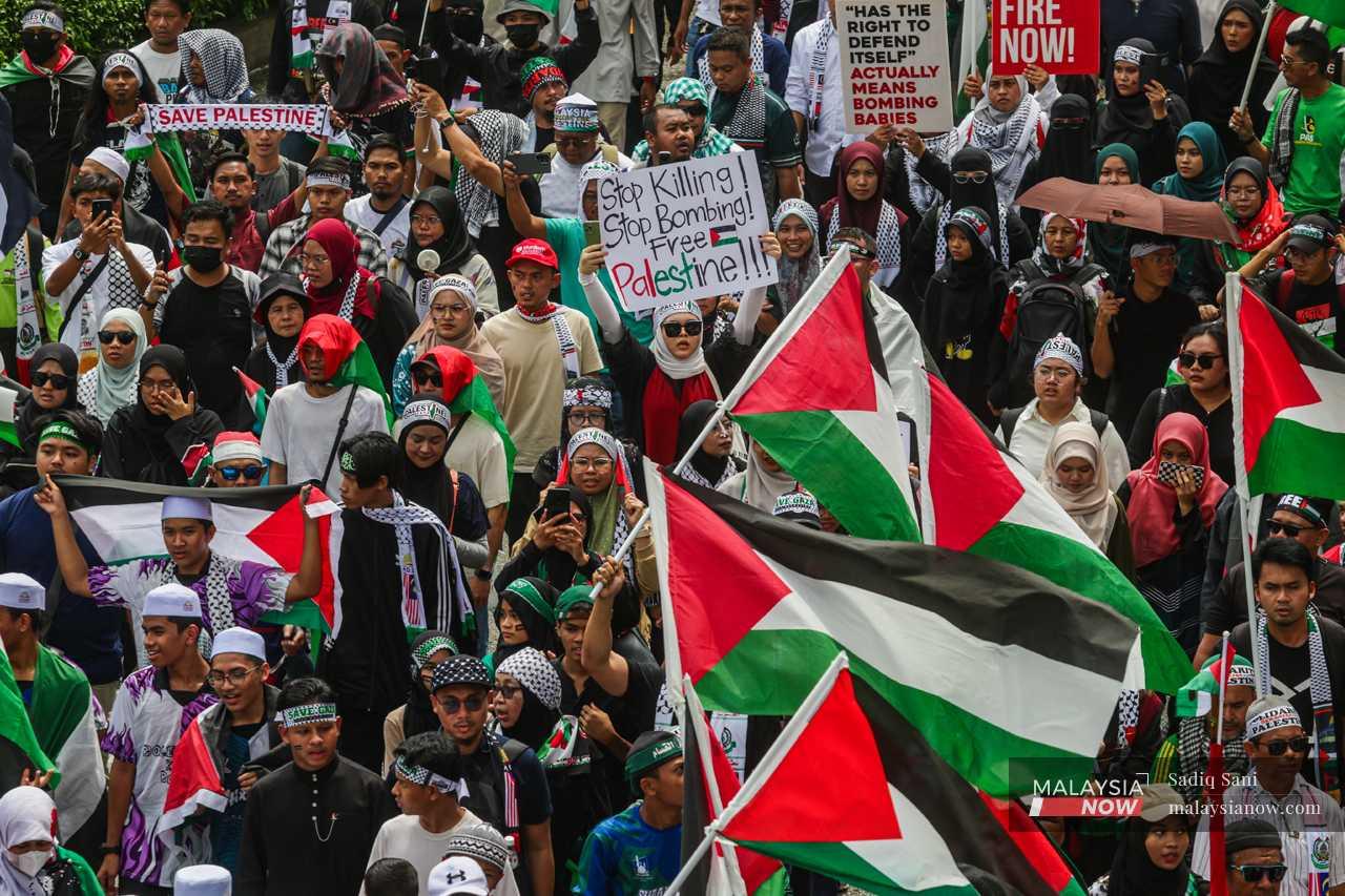 Protesters wear all manner of paraphernalia and wave Palestinian flags as they march towards the US embassy.