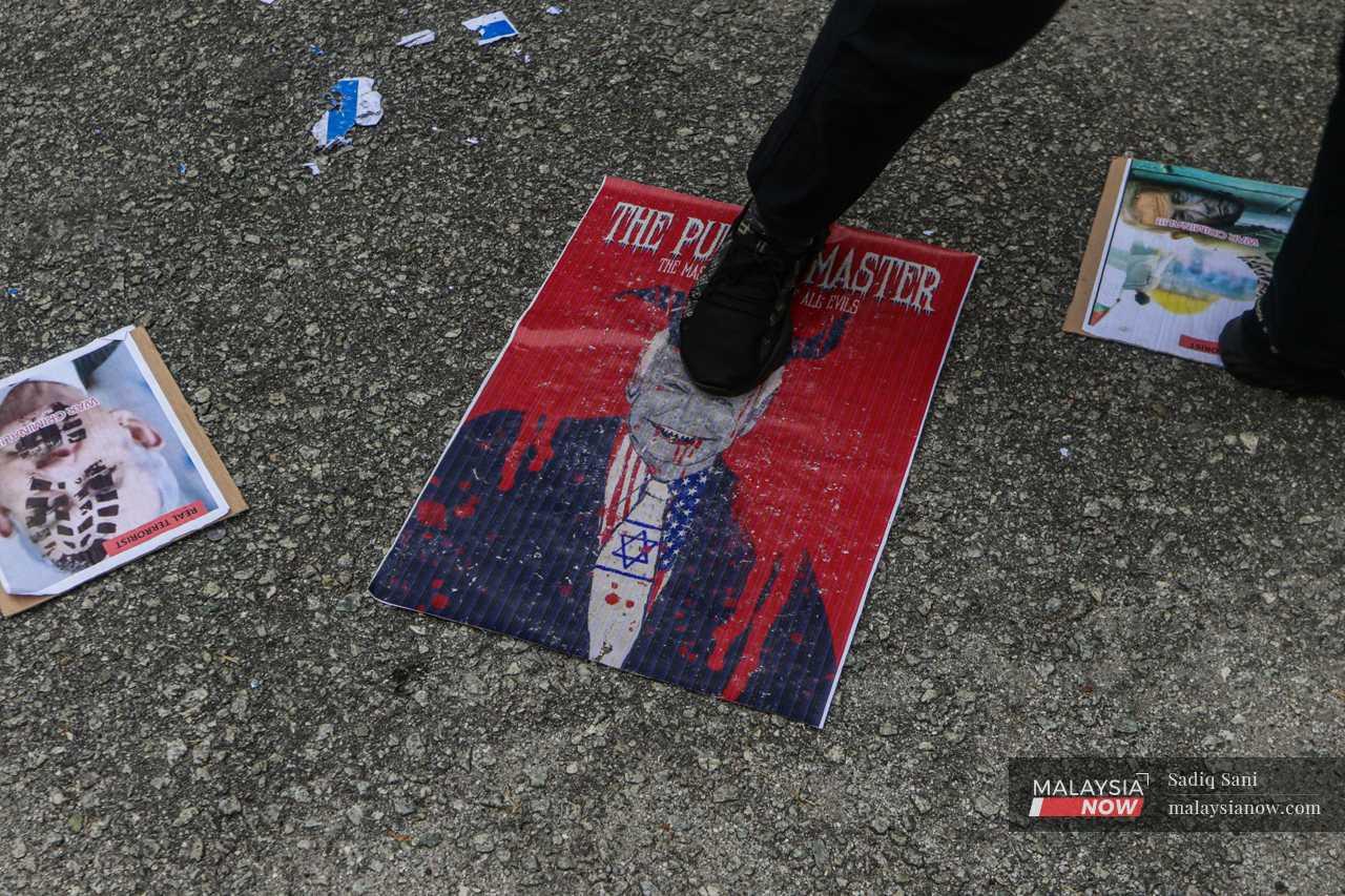 A protester steps on an image of US President Joe Biden outside the US embassy in Kuala Lumpur.