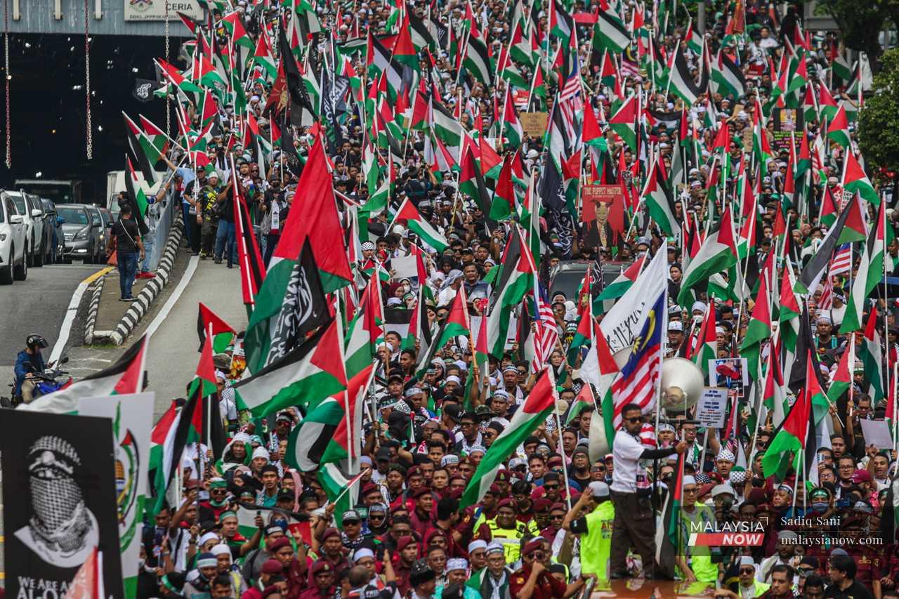 A sea of Palestinian and Malaysian flags is seen as protesters approach the US embassy in the largest anti-Israel protest this month.
