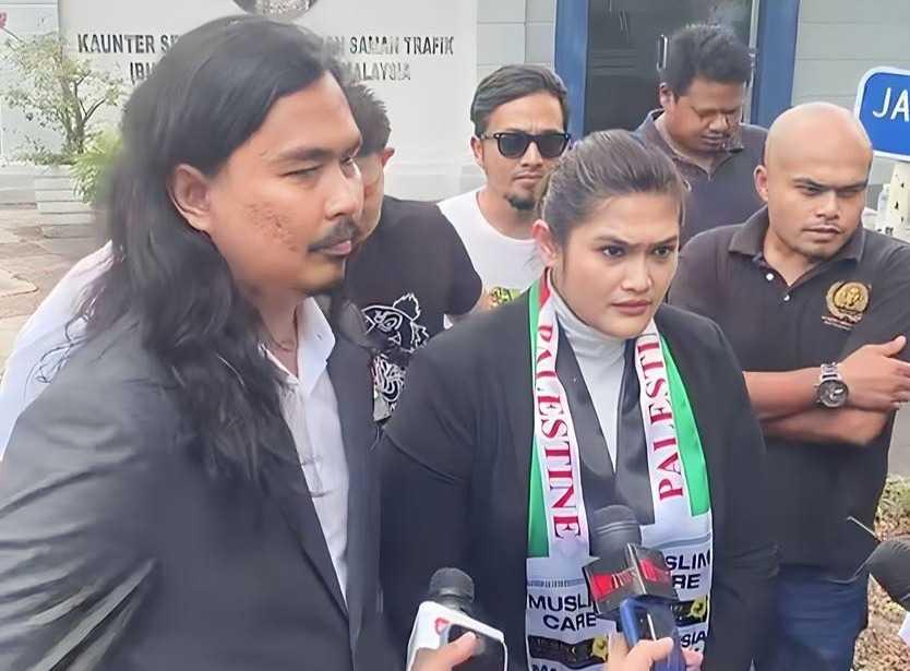 Lawyers for Liberty's Zaid Malek (left) with Syarul Ema, better known as Ratu Naga, outside the Bukit Aman police headquarters yesterday.