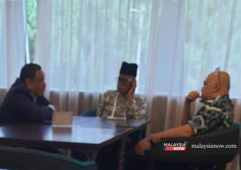 Langkawi MP Mohd Suhaimi Abdullah (centre) with two men during one of the 'discussions' with opposition MPs in Parliament this week.