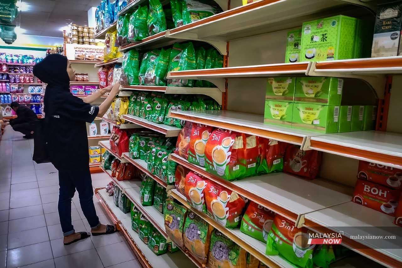 Seorang pengunjung di sebuah pasar raya di Selangor meneliti barangan. Sejak Israel melancarkan kempen pengeboman di Gaza, beberapa produk tempatan dilaporkan laris disebabkan pengguna Islam memboikot beberapa jenama antarabangsa.