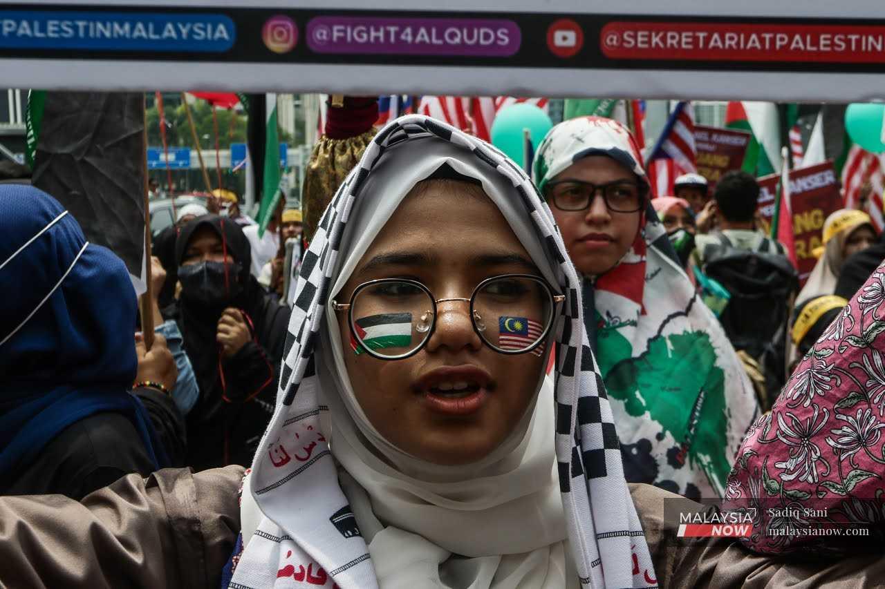 Seorang wanita mempamerkan bendera Malaysia dan Palestin di kedua belah pipi dalam satu perarakan Hari Al-Quds di luar Kedutaan AS pada 14 April, 2023.