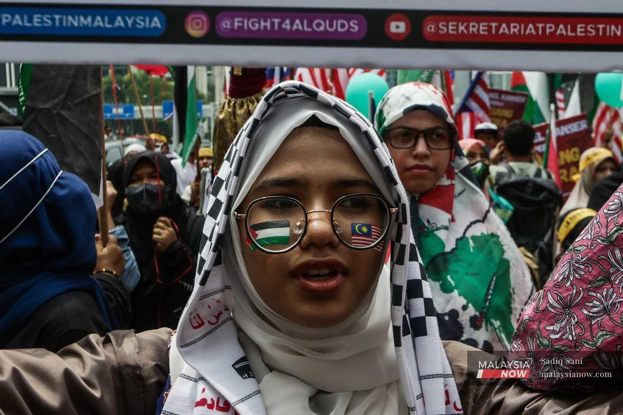 Seorang wanita mempamerkan bendera Malaysia dan Palestin di kedua belah pipi dalam satu perarakan Hari Al-Quds di luar Kedutaan AS pada 14 April, 2023. 