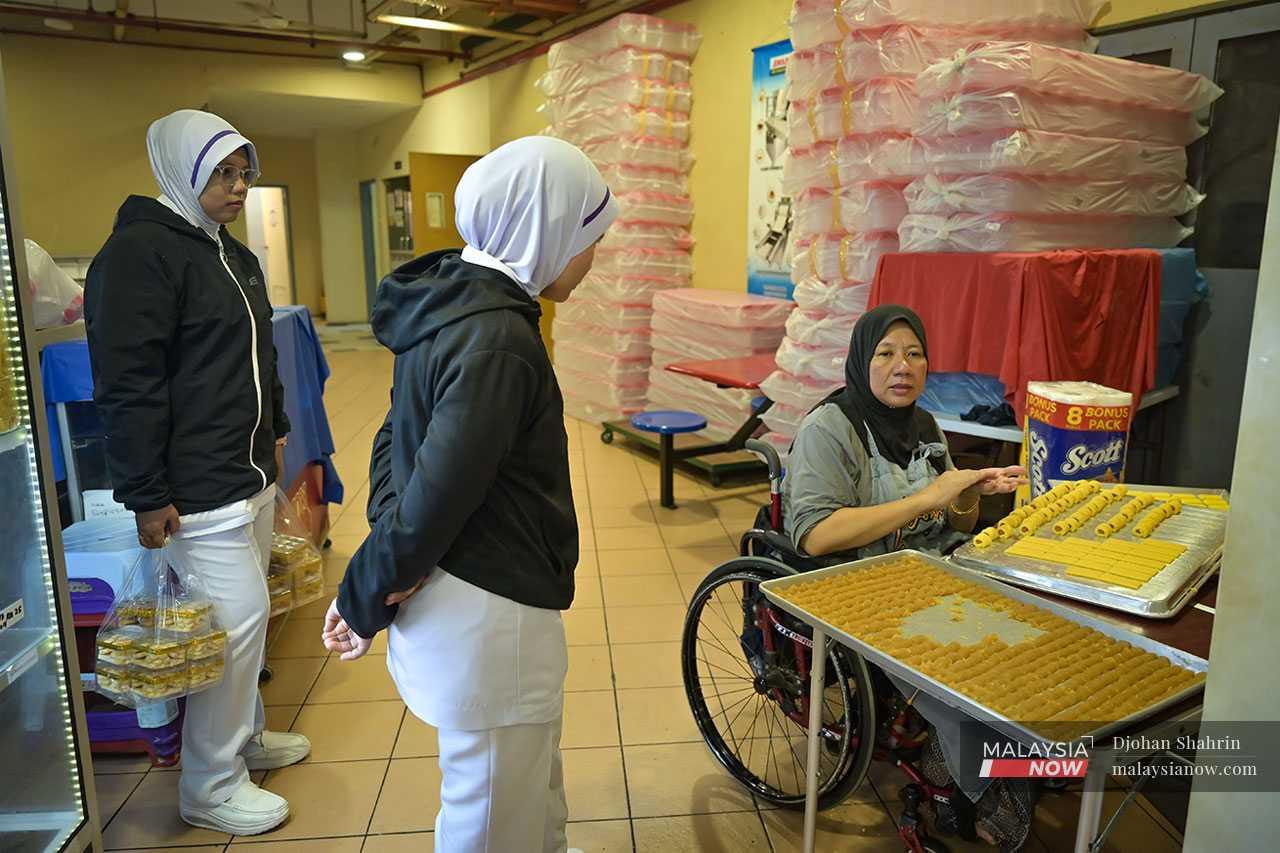 Customers collect their orders from Noorlizah Salman, who has been paralysed from the waist down since she was 16 years old. Although she is wheelchair-bound, she has run a successful business for the past 10 years, supplying cookies and kuih for festive seasons.