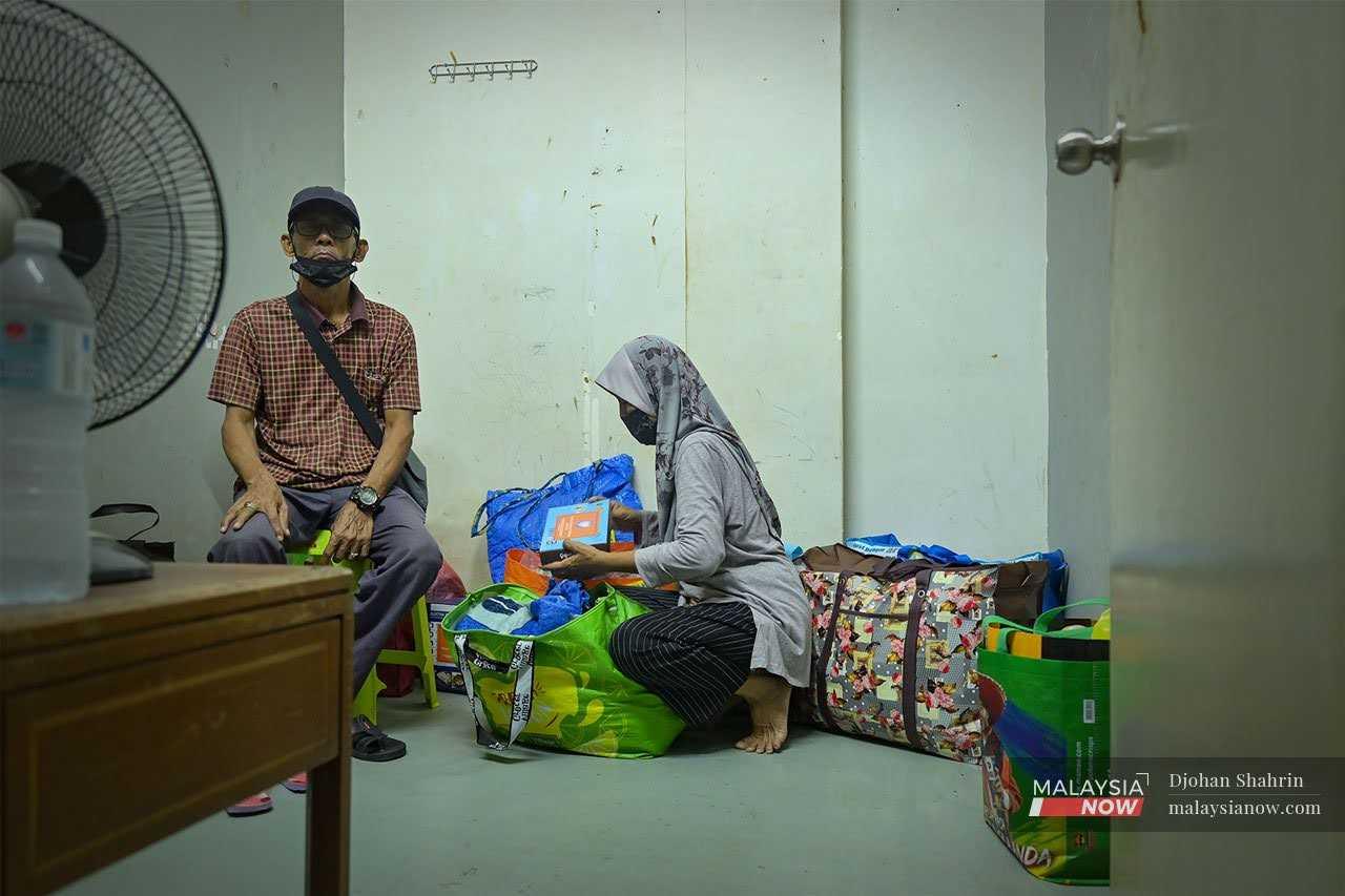 Zaleha Haron dan suaminya selepas menyusun barangan mereka di bilik sewa yang kini menjadi kediaman pasangan gelandangan itu di Kuala Lumpur.