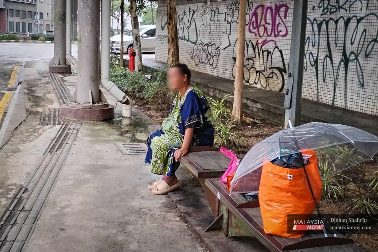 Lost in thought: Originally from Indonesia but now homeless in the big city, a woman stares off into the distance.
