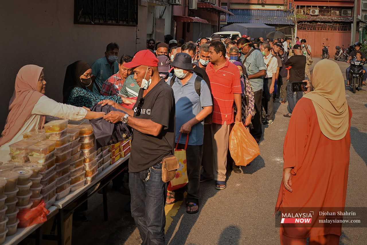 A charity group hands out containers of food to the urban poor.