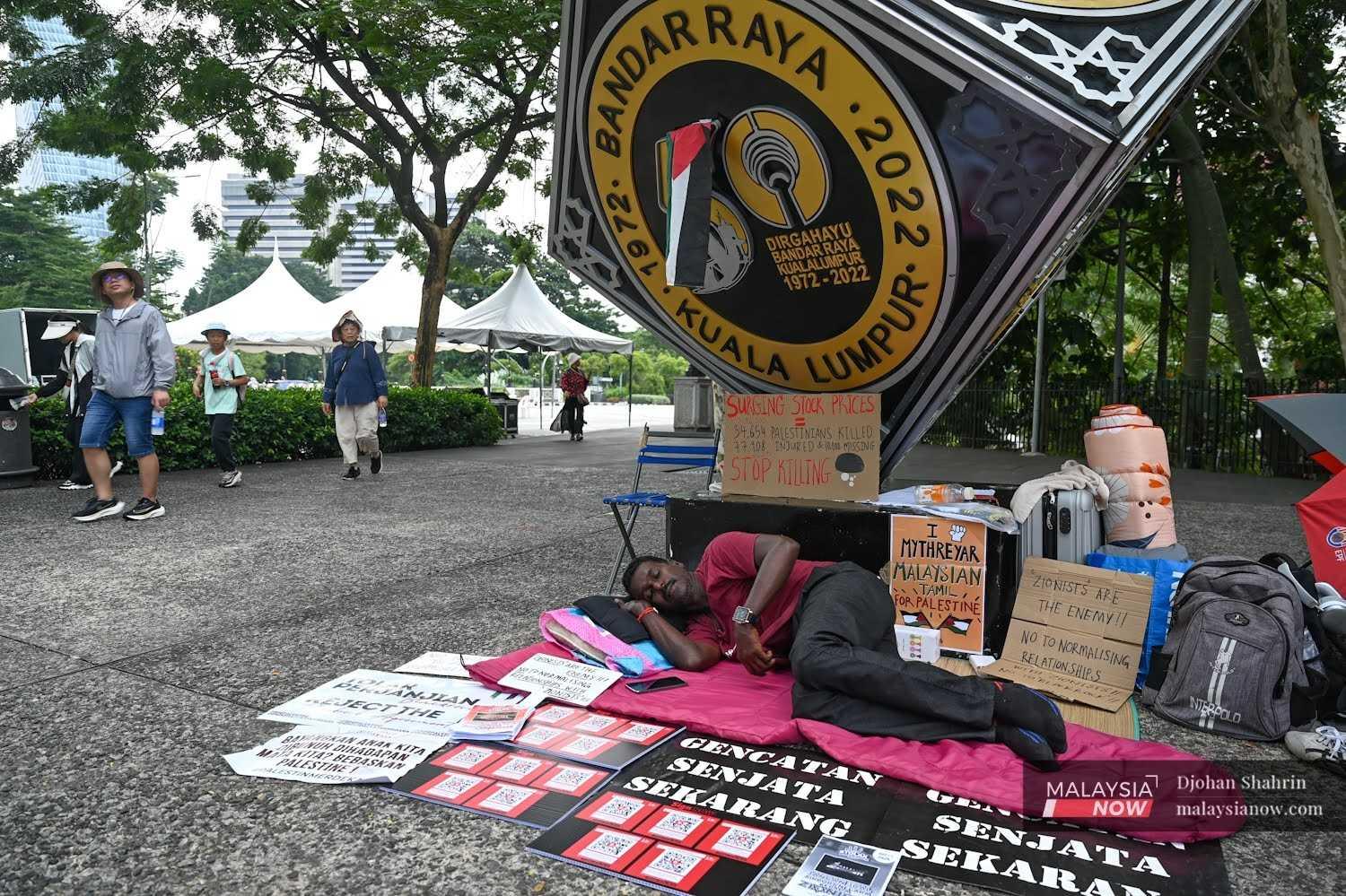 Mythreyar Mutturamalinggam berbaring di suatu sudut di Dataran Merdeka dikelilingi sepanduk menggesa kerajaan membatalkan rancangan membawa masuk firma milik BlackRock ke dalam konsortium mengurus lapangan terbang.