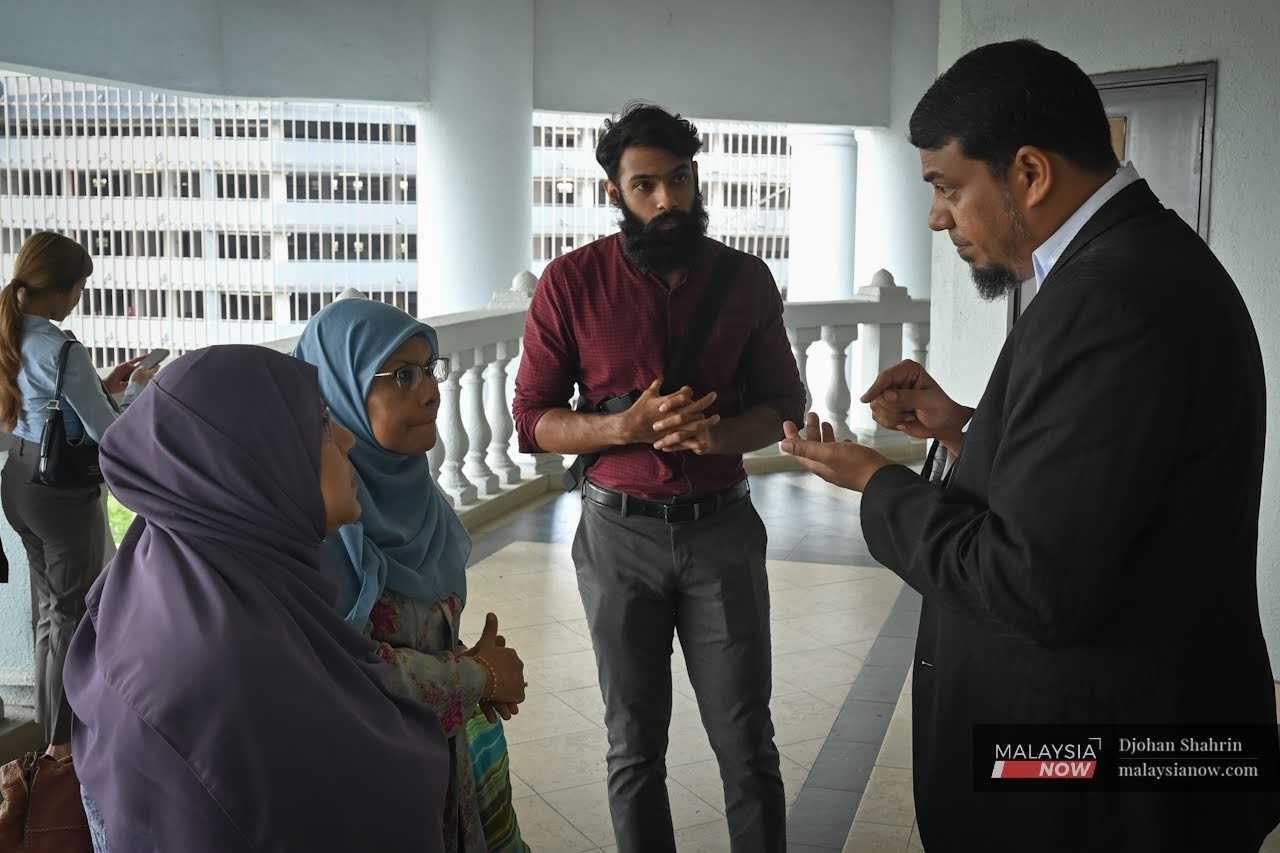 Peguam Rafique Rashid berkata sesuatu kepada ahli keluarga Yusoff Rawther di Kompleks Mahkamah Kuala Lumpur hari ini.