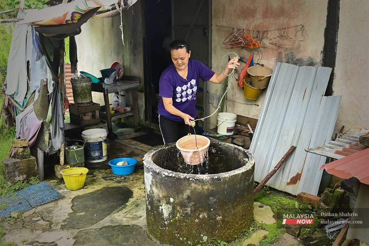 Yap Su Chong draws water from an old well from the old well at the back of her house in Tanjung Malim, but the water is dirty and unfiltered.