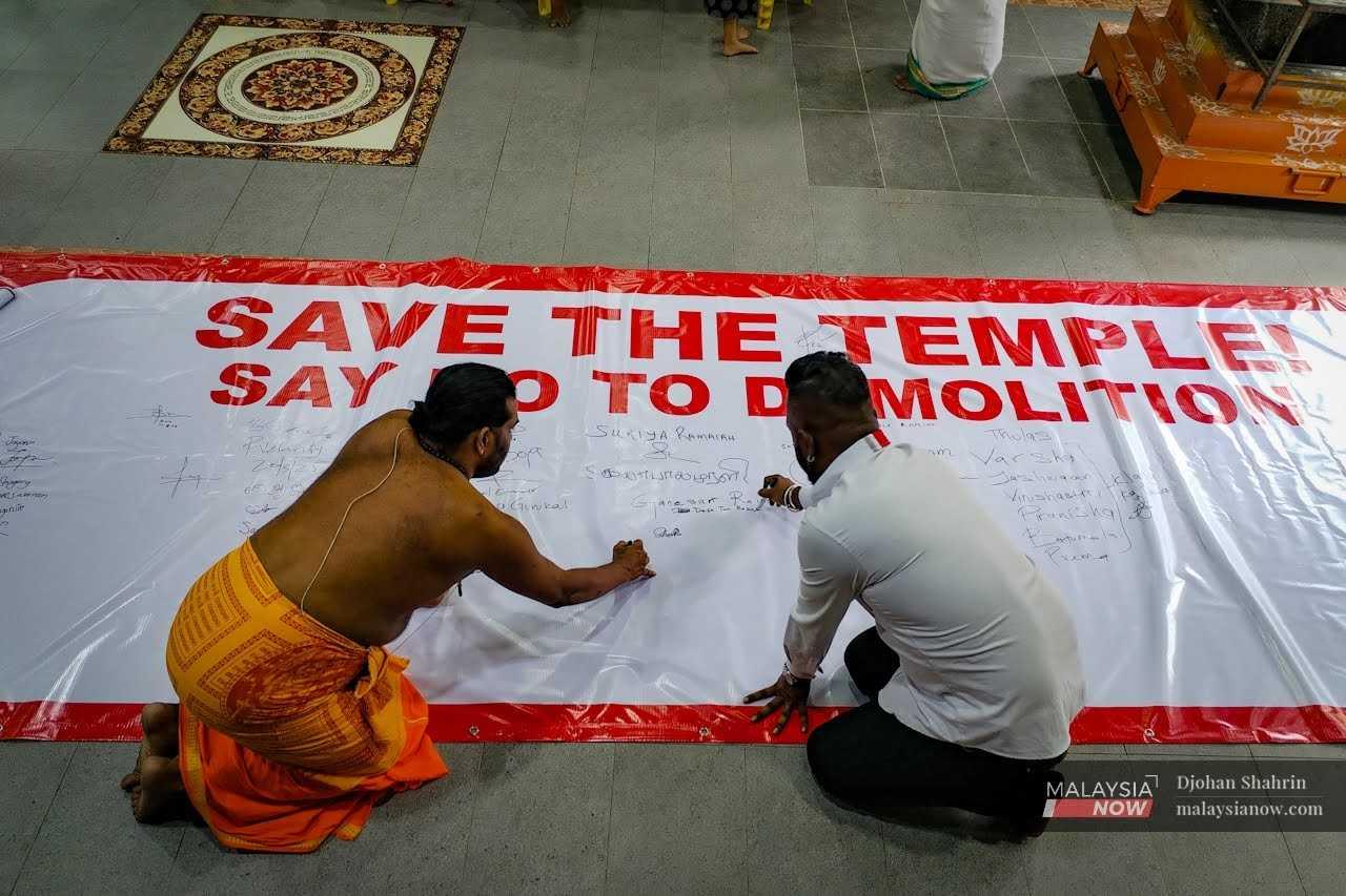 Devotees sign a banner calling for the preservation of the Dewi Sri Pathrakaliamman Temple in Kuala Lumpur in the face of pressure from ruling politicians.