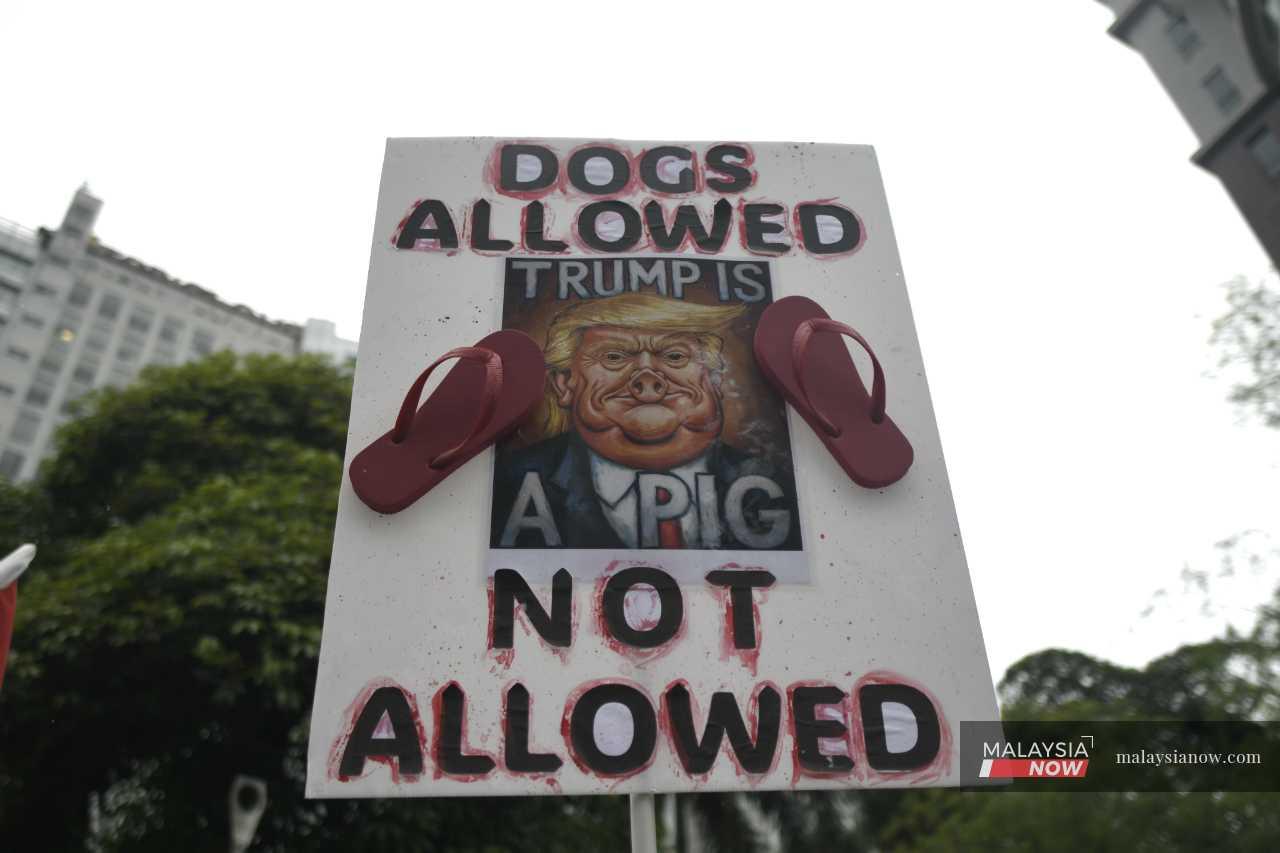 A protester displays a placard mocking Donald Trump during a rally in Kuala Lumpur to protest the US leader's visit to Malaysia this month.
