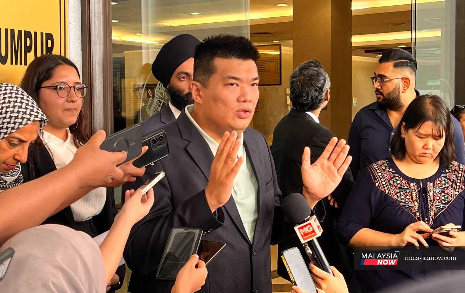 Albert Tei, ditemani barisan peguamnya, di luar Mahkamah Tinggi Kuala Lumpur hari ini.