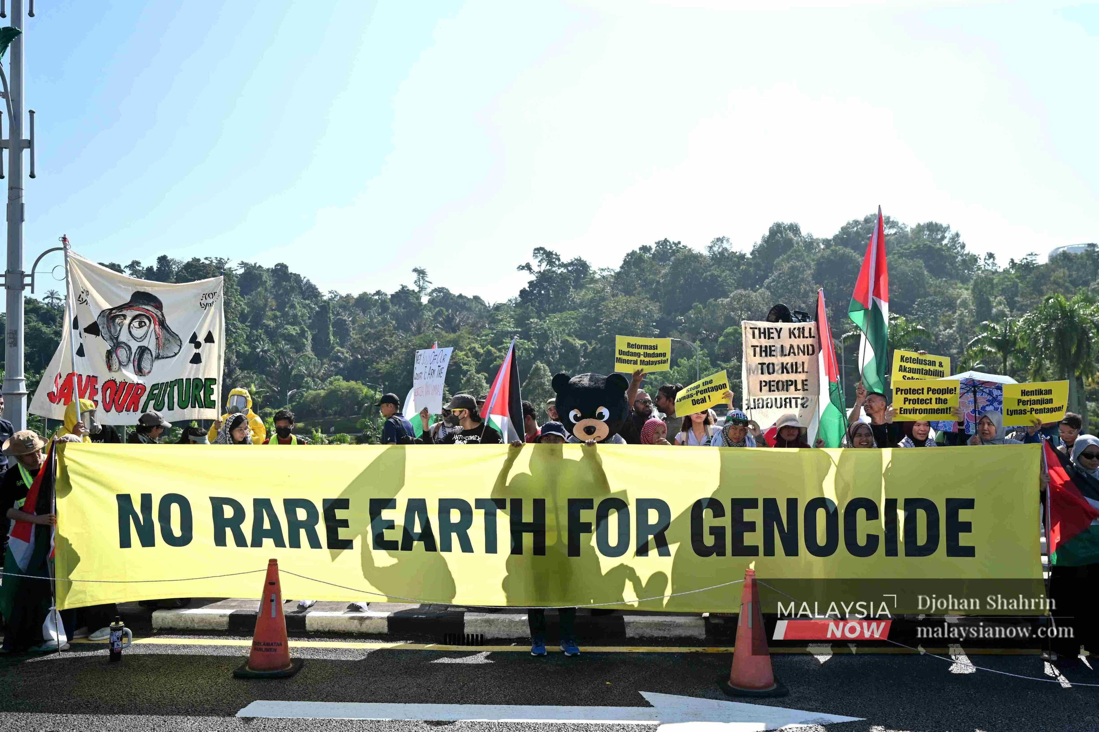 Protesters march outside the Parliament building, urging the government to suspend Australian mining company Lynas’ operations in Malaysia for agreeing to sell rare earths to the Pentagon.
