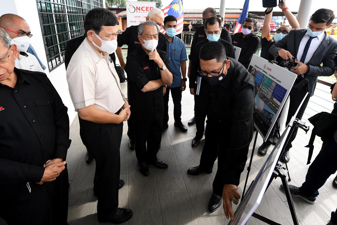Perdana Menteri Muhyiddin Yassin mendengar penerangan daripada Menteri Besar Perak Ahmad Faizal Azumu ketika membuat lawatan di Jeti Pangkor sempena lawatan kerja beliau hari ini. Gambar: Bernama
