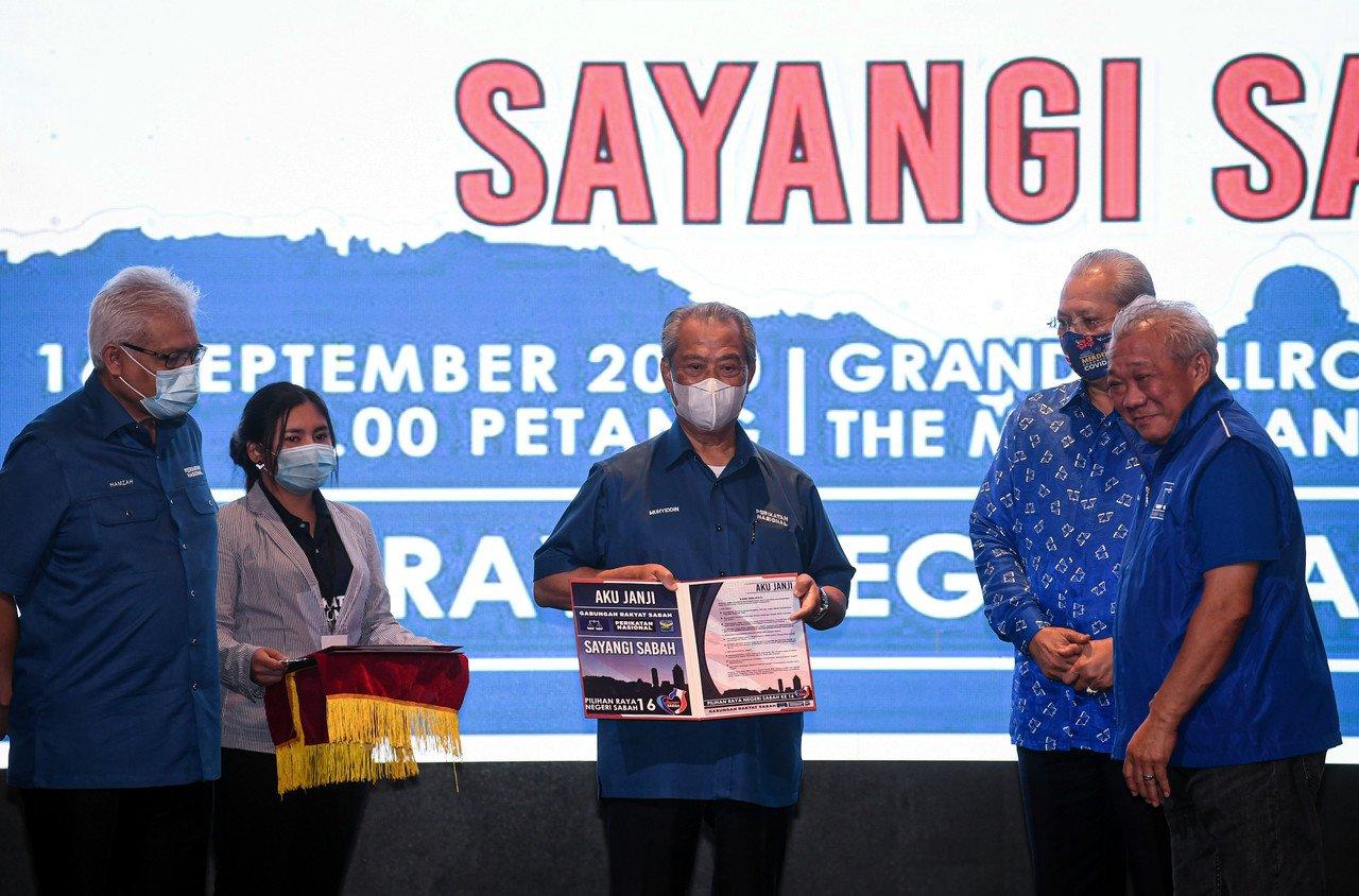 Perdana Menteri Muhyiddin Yassin menunjukkan risalah simbolik Aku Janji Gabungan Rakyat Sabah yang diserahkan oleh Pengerusi BN Sabah Bung Moktar Radin pada Majlis Pelancaran Aku Janji Gabungan Rakyat Sabah (GRS) untuk Perikatan Nasional (PN) dan Barisan Nasional (BN) bagi Pilihan Raya Negeri Sabah di Grand Ballroom Magellan Sutera Harbour Golf & Country Club di Kota Kinabalu hari ini. Gambar: Bernama