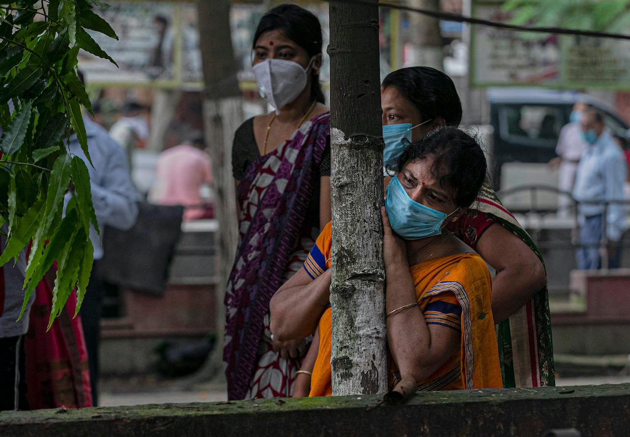 Women mourn from a distance after seeing the body of a relative who died of Covid-19 in Gauhati, India, Sept 10, 2020. Photo: AP