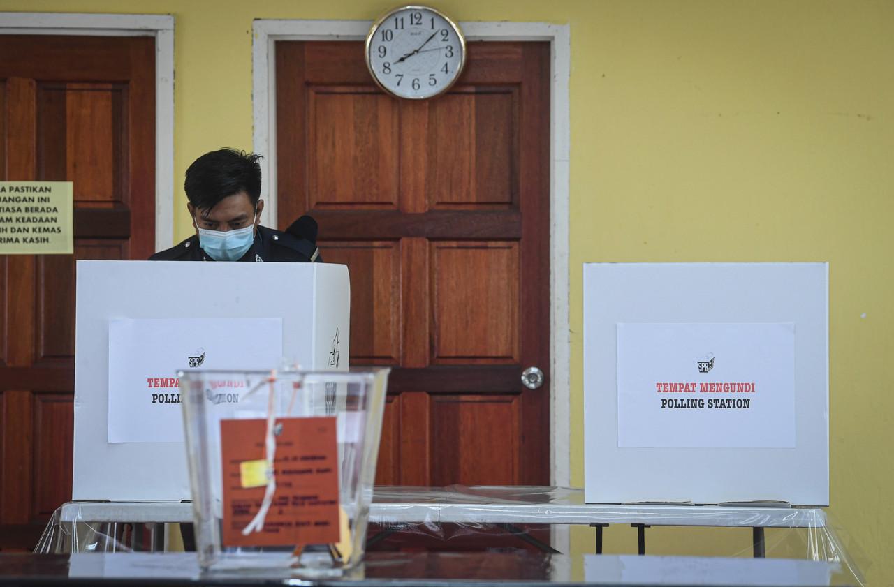 A police officer takes part in the early voting process for the Sabah state election today. Photo: Bernama