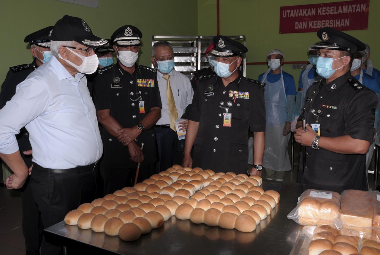 Menteri Dalam Negeri Hamzah Zainudin (kiri) melihat aktiviti pembuatan roti para banduan Penjara Kajang selepas Majlis Sambutan Hari Penjara ke-230 di Ibu Pejabat Penjara Malaysia, Kajang pada 25 Ogos 2020. Gambar: Bernama