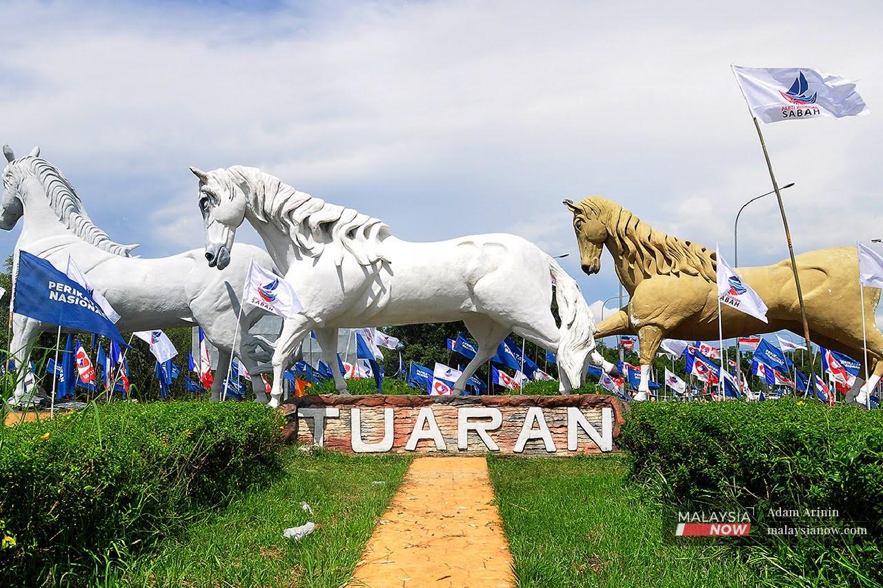 Party flags wave in the air at Bulatan Kuda Jalan Sulaman, a landmark in the district of Tuaran, ahead of the state election on Sept 26.