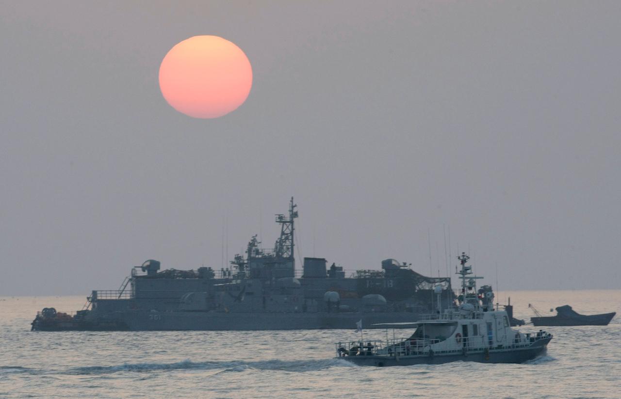 In this Dec 22, 2010 file photo, a government ship sails past the South Korean Navy's floating base as the sun rises near Yeonpyeong island, South Korea. Photo: AP