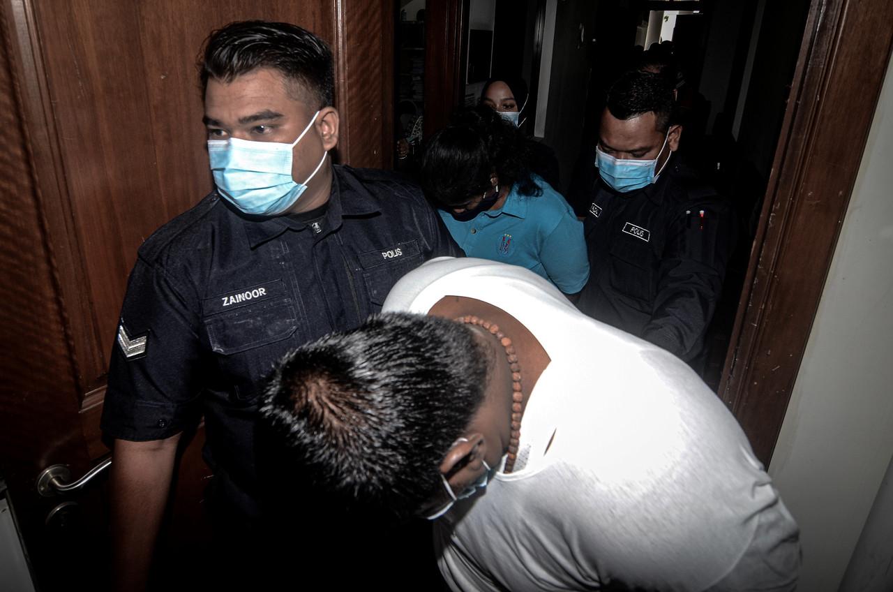 R Saravanan Kumar (in front) and T Gayathry accompanied by police at the George Town High Court today. Photo: Bernama