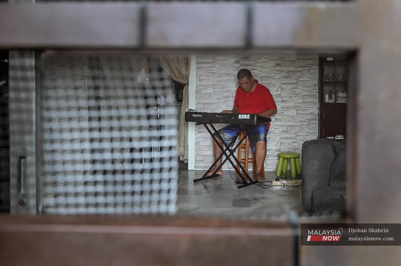 Mohd Zawawi Jusoh practises on his keyboard in his home in Taman Bukit Kenangan, Kajang.