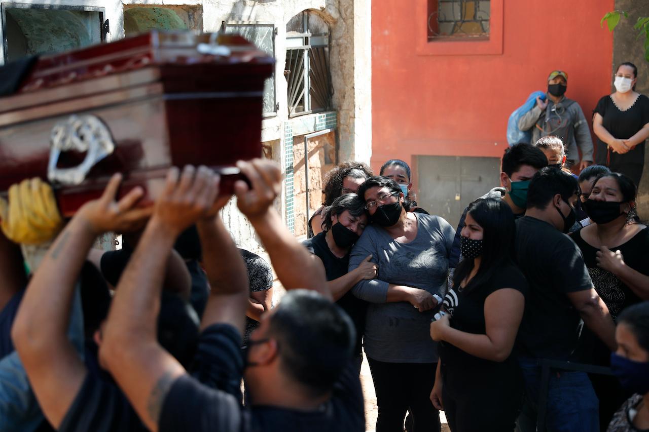Relatives of a taxi driver who died from Covid-19 related complications mourn during his burial at Asuncions's Recoleta Cemetery in Paraguay on Sept 22. Photo: AP
