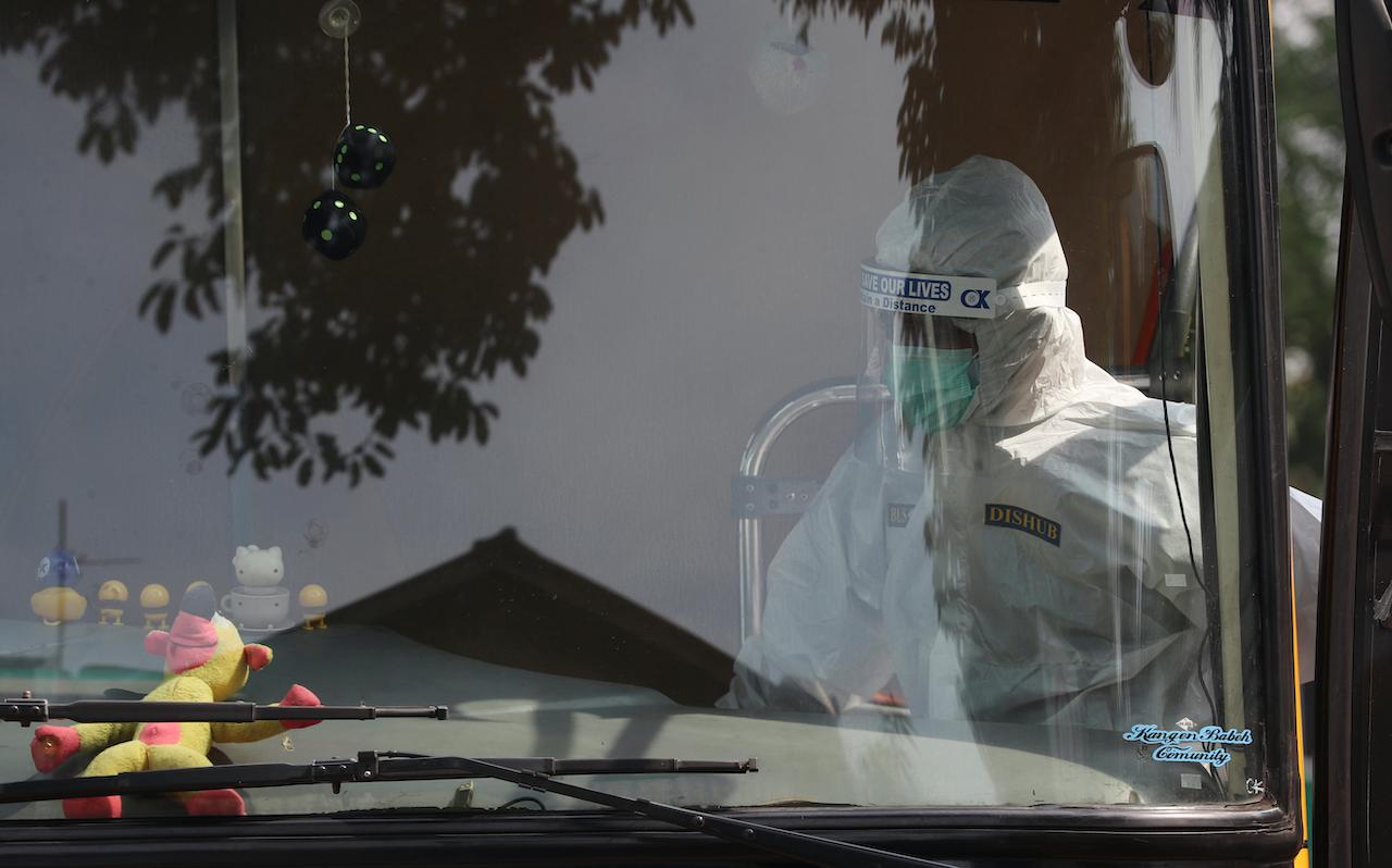 A bus driver prepares to drive to a quarantine facility for people showing symptoms of the coronavirus in Jakarta, Indonesia on Sept 25. Photo: AP