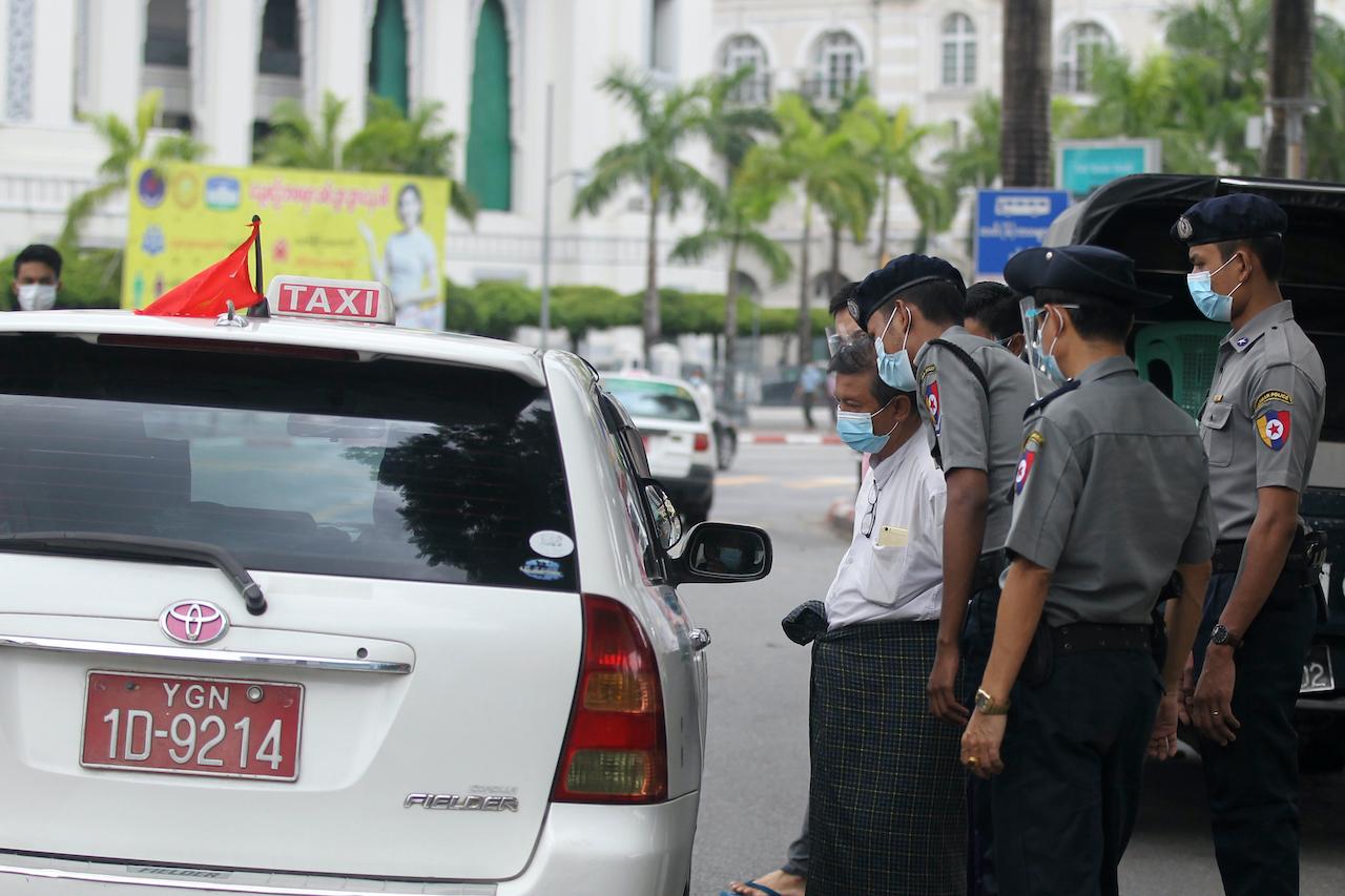 Police officers check passengers for documents to prove they are allowed to travel from one township to another amid coronavirus restrictions imposed in Yangon, Myanmar on Sept 28. Photo: AP