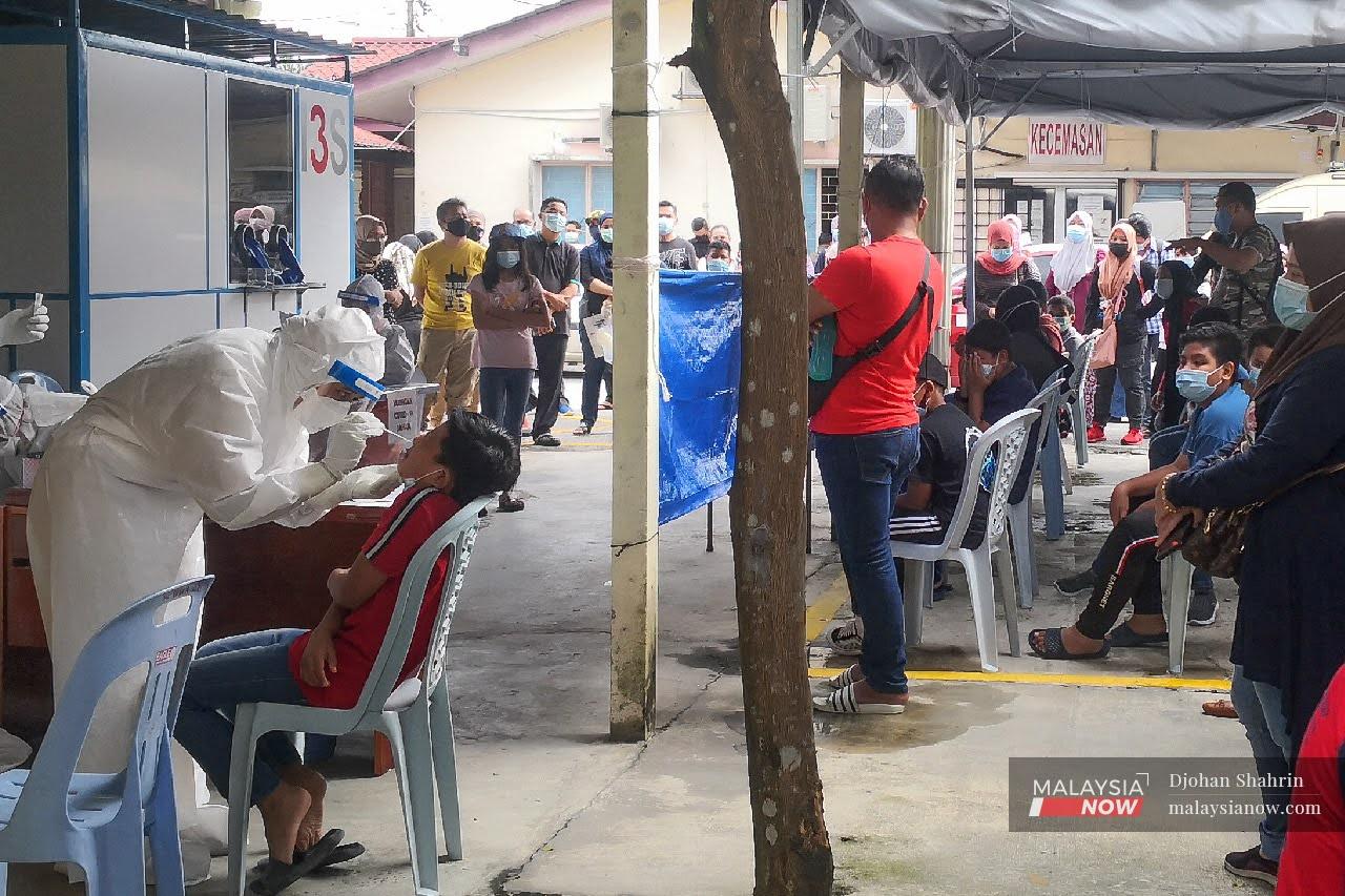 Petugas Kesihatan menjalankan pemeriksaan saringan Covid-19 kepada murid-murid dari Sekolah Kebangsaan Taman Tasik, Ampang.